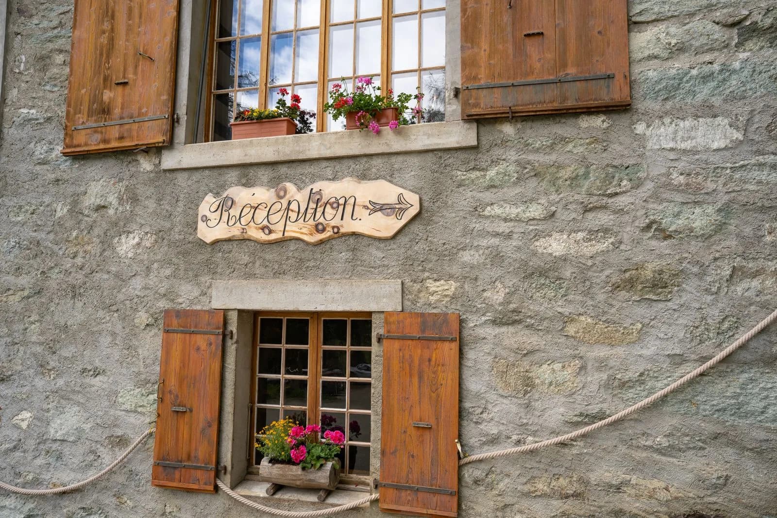 Panneau « Réception » peint à la main sur la façade en pierre du Grand Hôtel & Kurhaus — Arolla