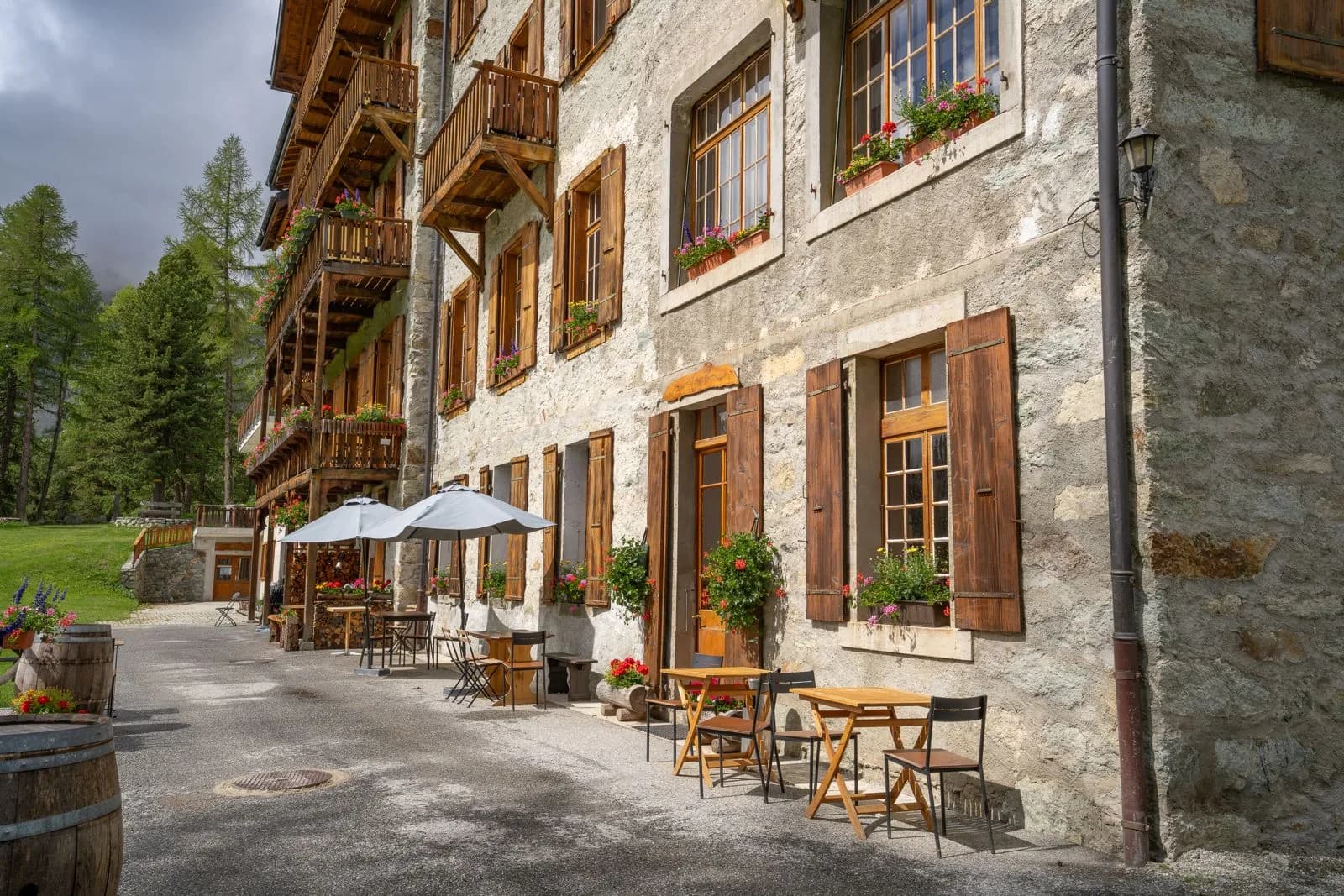La terrasse de l'hôtel avec parasols le long de la façade en pierre — Grand Hôtel & Kurhaus Arolla