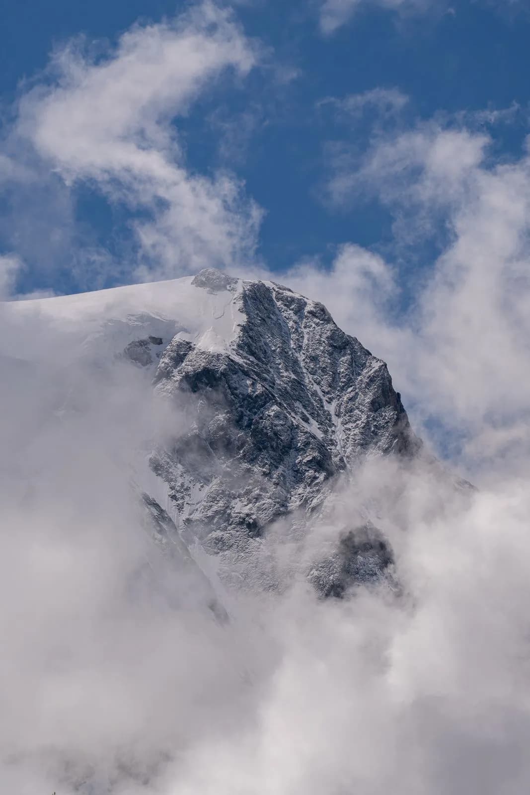 Sommet glaciaire d'Arolla émergeant des nuages — étape de la Haute Route à ski