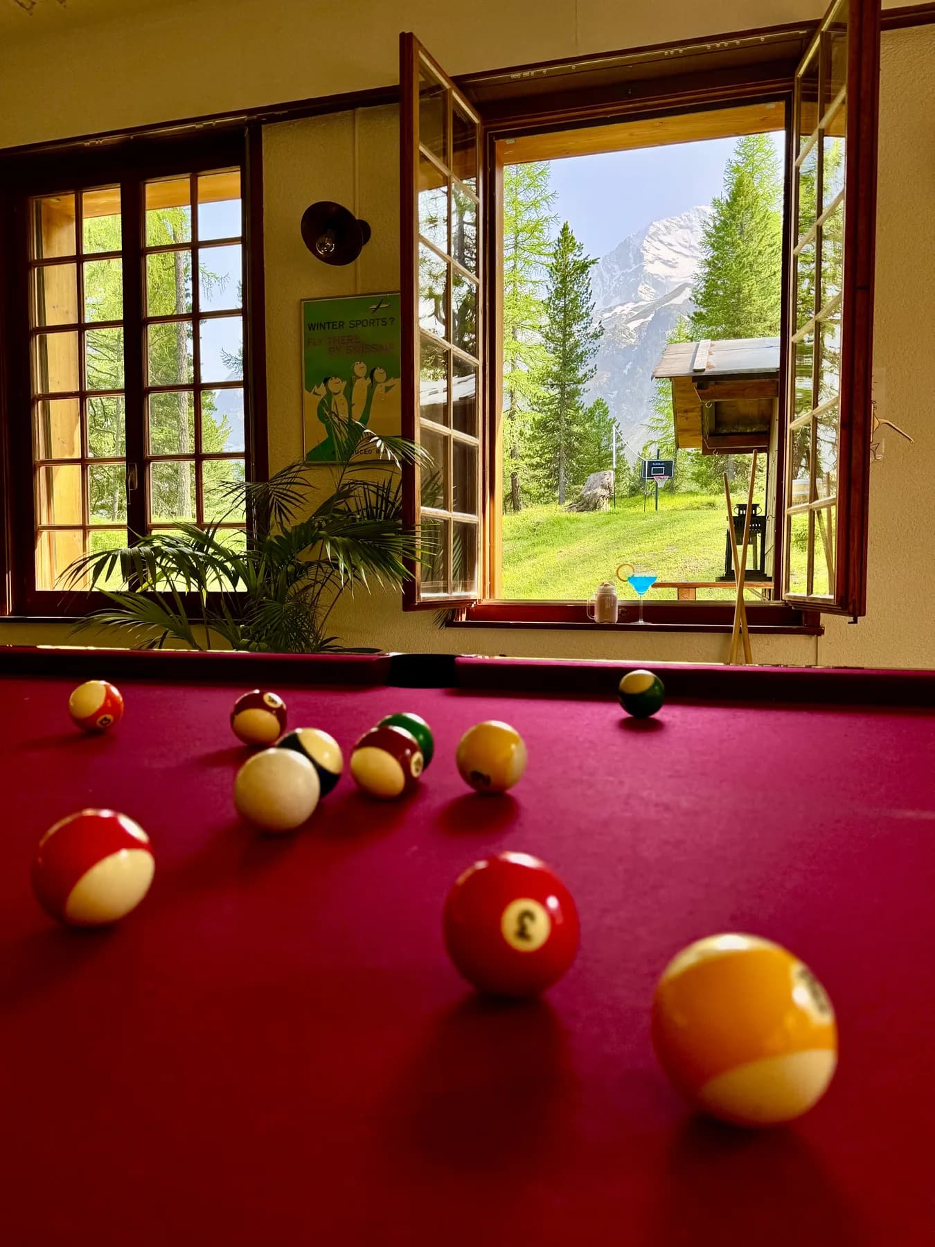 Le Pub — table de billard face à la fenêtre ouverte sur le Mont-Collon en été, Grand Hôtel & Kurhaus Arolla
